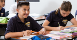 Student smiling at desk